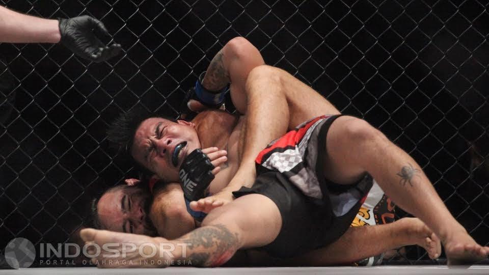 Petarung asal Belanda, Anthony Engelen (belakang) mengunci lawannya petarung asal Filipina, Rocky Batolbatol.